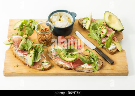 Oignon pain rustique avec du fromage à la crème, jambon de Parme, roquette,avocat,le thym,tomate,chili caillé et studio Banque D'Images