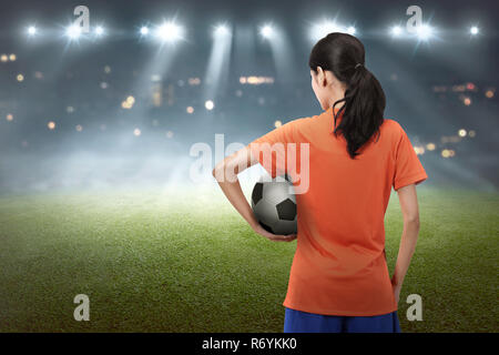 Jeune joueur de football asiatique femme transportant la balle Banque D'Images