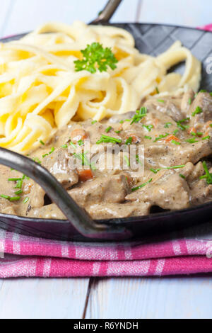 Bandes de viande frits dans une sauce à la crème dans une casserole Banque D'Images