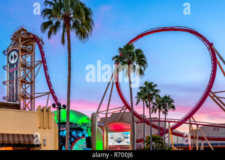 ORLANDO, FLORIDE, USA - DÉCEMBRE, 2017 : Les cavaliers profiter le Rip Ride Rockit Rollercoaster au parc à thème Universal Studios dans un beau coucher de soleil rose Banque D'Images