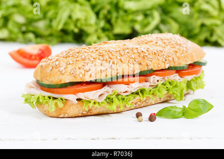 Rouleaux complets baguette sandwich garni de jambon sur planche de bois Banque D'Images