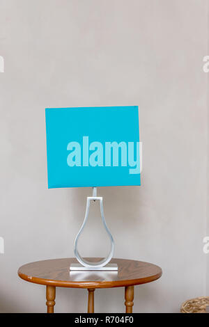 Abat-jour bleu isolé sur fond mur beige.Une lampe de table dans les tons de gris et turquoise.salon moderne.Intérieur de maison moderne, détail salon, lampe de table Banque D'Images