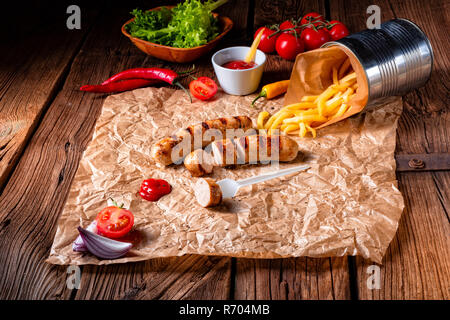 Bratwurst rustique avec pommes et ketchup fort Banque D'Images