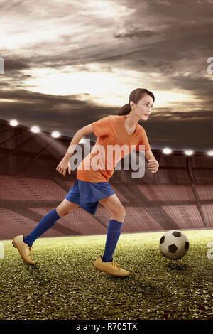 Le joueur de soccer féminin asiatique professionnel en action avec la balle Banque D'Images