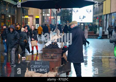 Châtaignes chaudes à vendre par un vendeur de rue qui se trouve à l'extérieur de l'entrée du centre commercial westfield de stratford vers l'heure de Noël. Banque D'Images