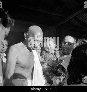 Mahatma Gandhi et Pyarelal Nayar portant sa nièce Nandini à Seagram Ashram, Wardha, Maharashtra, Inde, août 1944, ancienne image vintage du 1900 Banque D'Images