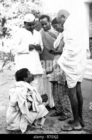 Mahatma Gandhi parlant à un villageois aveugle dans Bihar, Inde, mars 1947, vieille image millésime 1900 Banque D'Images