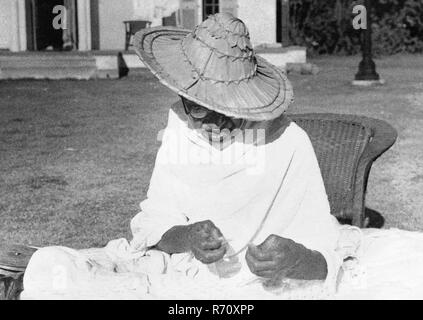 Mahatma Gandhi portant un chapeau Noakhali tout en tournant à Birla House, New Delhi, Inde, novembre 1947, ancienne image vintage 1900 Banque D'Images