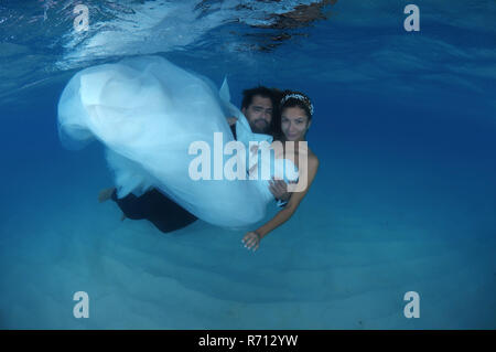 Groom holding la mariée dans ses bras sous l'eau, de l'Océan Indien, les Maldives Banque D'Images
