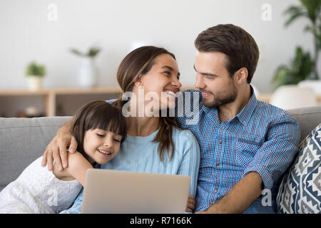 Famille diversifiée passer du temps libre à la maison à l'aide d'ordinateur portable Banque D'Images