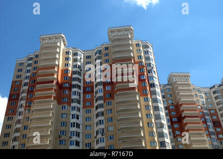 Section supérieure de l'immeuble moderne construit à partir de briques plus de ciel bleu avec des nuages blancs sur la journée d'été Banque D'Images