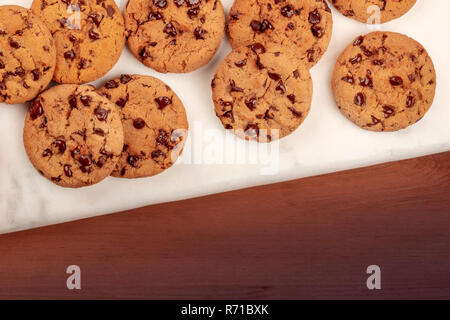 Une photo de haut en bas du golden brown chocolate chip cookies, tourné par le haut sur un fond de bois rustique foncé with copy space Banque D'Images