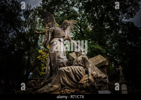 Jésus Christ avec croix sur le sol béni par un Ange, l'art chrétien expressif dans vieille nécropole, la sculpture sur pierre dans le cimetière Rakowicki à Cracovie Banque D'Images