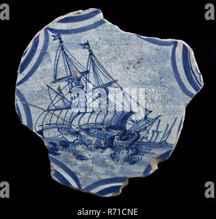 Majolique Fragment lave, bleu sur fond blanc, voile de bateau sur l'état de la mer, lave vaisselle plaque de sol en céramique faïence titulaire trouver glaçage glaçage glaçage, étain plomb tournées à la main glacé frit miroir plat cuit décoré de grand plat sur support anneau. Glaçure plombifère shed jaune en bas très bosselé tin glaze en haut représentation monochrome en bleu composé de voilier gréé en Bogendecor la mer agitée autour de l'exposition. Au four à bois de Delft Voir la carte Présentation Stadsdriehoek Rotterdam archéologie poterie autochtone décorer servir des aliments table de service de découverte du sol : Delftse Vaart Rotterdam 1941. Banque D'Images