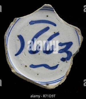 Bol en faience de fragment avec décoration bleu sur fond blanc, datée du 1663, titulaire de la vaisselle Bol en céramique faïence sol trouver tin glaze glaçure, tournées à la main cuit 2x vitrage Fragment de bol en faïence avec décoration bleu sur fond blanc. Fragment de miroir avec la datation en deux cercles bleus. L'écharde jaune cuit Standring sur miroir date : 1663 terrain de l'héliport de Rotterdam archéologie poteries indigènes servant de la nourriture servant de sol table découverte : Juin 1978 site de l'héliport. Banque D'Images