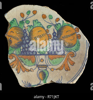 IA ( ?), sol plat en majolique polychrome fragment avec bol de fruits dans le miroir, signé, lave vaisselle plaque de sol en céramique faïence titulaire trouver glaçage glaçage glaçage, étain plomb anneau 10,1 part devenu glacé décoré au sol frit sur support. Bol de fruits polychrome dans le miroir dans les couleurs vert orange bleu avec des grenades et des grappes de raisin bol à fruit stand élevé. Glaçure plombifère épargnant dos verdâtre Signature dans l'anneau de support en mode signature bague : IA pas sûr archéologie Triangle ville hôtel de ville hôtel de ville de Rotterdam poteries indigènes servant jusqu'à décorer le sol alimentaire découverte de Ro Banque D'Images