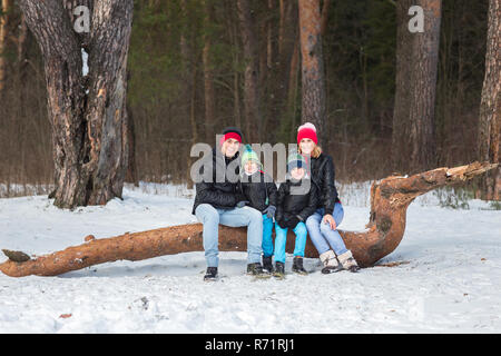 Heureux balades familiales et en jouant avec la neige en forêt d'hiver Banque D'Images