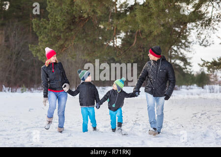 Heureux balades familiales et en jouant avec la neige en forêt d'hiver Banque D'Images