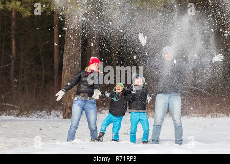 Heureux balades familiales et en jouant avec la neige en forêt d'hiver Banque D'Images