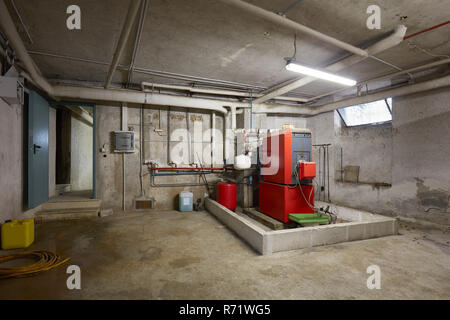 Sous-sol avec chaudière de chauffage rouge dans la région de old house interior Banque D'Images