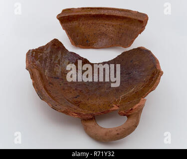 Des fragments d'argile rouge et grès cou de Groenendaal en cloaque, Pot de rangement porte-pot en faïence céramique trouver sol plomb glaze glaçure, cuite vernissée décorées tournées à la main et de poterie en grès, à partir de fragments des fragments de cesspit pot de stockage de grande décoration avec le sabot à l'épaule avec standlob fragment bas bord de la plaque de cuisson de fragment. Fragment de mur avec la moitié de l'oreille de faïence émaillée verseuse en grès de fragment de col. brun et gris sel glaze archéologie le centre-ville de Rotterdam Stadsdriehoek fosse souterraine de Groenendaal grès faïence fosse souterraine Groenendaa Banque D'Images