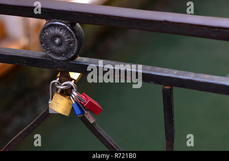 Groupe des cadenas accroché à la rambarde d'un pont, de différentes couleurs, rouge, bleu, jaune et métallique grar. Photo conceptuelle de l'amour et l'engagement Banque D'Images