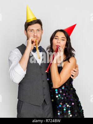 Couple heureux avec party blowers s'amusant Banque D'Images