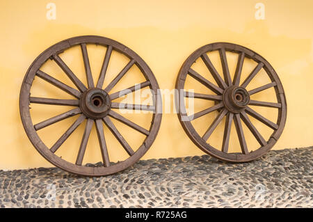 Deux vieilles roues en bois du chariot sur un étage de gallets Banque D'Images