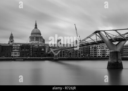London, England, UK - 3 Avril 2018 : La Tamise coule sous London's Millennium Bridge, avec la Cathédrale St Paul et les blocs de bureau de la ville f Banque D'Images