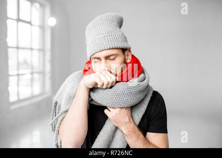 Portrait d'un homme enveloppé dans un cadre chaleureux et foulards hat se sentir mal d'avoir une maladie d'hiver à l'intérieur Banque D'Images