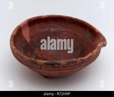 Pan de faïence, viennent avec schenklip sur le stand palmes, pan vaisselle Bol en céramique faïence sol porteur trouver glaze glaçure de plomb à la main, émaillés de cuvette ronde tourné au four avec schenklip le bord plié avec trois crêtes sur l'extérieur. Porté trois ailerons coincés dessous usées jusqu'à l'intérieur de la poterie rouge à l'extérieur glacé ici et là l'archéologie taches tunnel ferroviaire Rotterdam poterie autochtone cuisine food drink mélange découverte du sol : rail tunnel Rotterdam. Banque D'Images