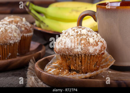 Libre d'une banane Muffin noix avec une tasse de café sur une plaque de bois avec des muffins et des bananes en arrière-plan Banque D'Images