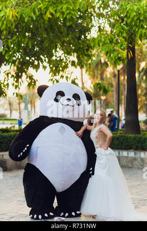 Un homme dans un costume de panda un confort femme blessée Banque D'Images