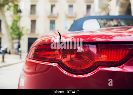 Détail de l'arrière rouge métallisé rouge phare de voiture en forme des yeux, avec la réflexion dans élève Banque D'Images