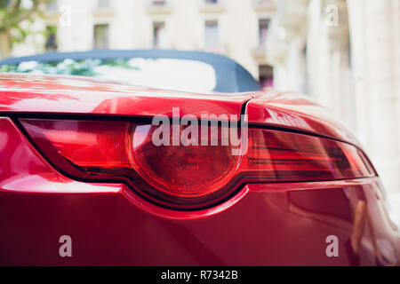Détail de l'arrière rouge métallisé rouge phare de voiture en forme des yeux, avec la réflexion dans élève Banque D'Images