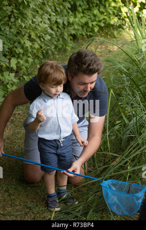 Le père et l'enfant à la recherche de filet de pêche Banque D'Images