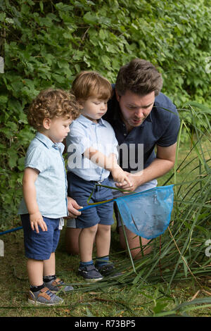Le père et les enfants à la recherche de filet de pêche Banque D'Images