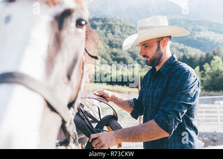 Les jeunes en milieu rural cheval selle cowboy arène équestre Banque D'Images