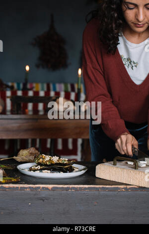 Young woman slicing nourriture sur planche, cropped Banque D'Images