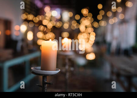 Close up de bougie allumée dans café avec des lumières décoratives Banque D'Images