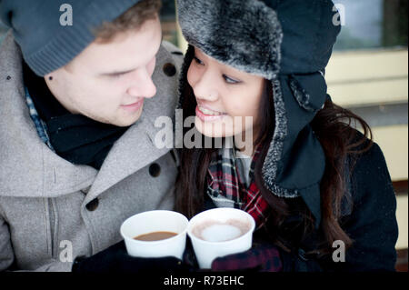 Jeune couple en hiver chapeaux ayant des boissons à emporter Banque D'Images