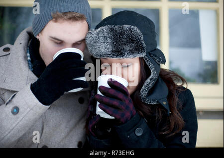 Jeune couple en hiver chapeaux de boire du café à emporter Banque D'Images