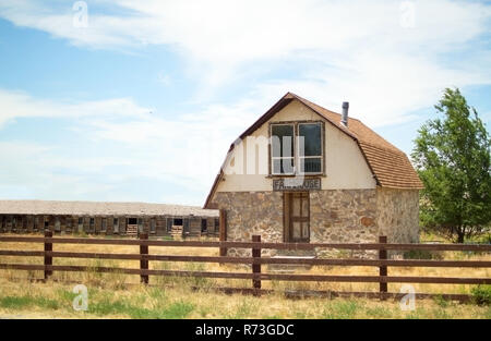 Une petite ferme, derrière une clôture sur un ciel bleu. Banque D'Images