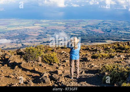 Tourisme une femme prise d'une photo en hauteur sur les pentes de Haleakala à bas vers la côte Nord de Maui, Hawaii, USA. Banque D'Images