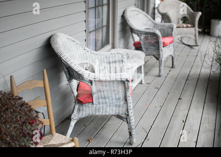 Les chaises en osier gris sur un porche. Banque D'Images