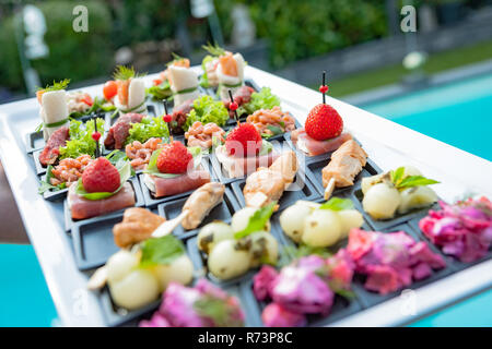 Petits plats sur un plateau avec une variété de fruits, légumes, poissons et viandes Banque D'Images