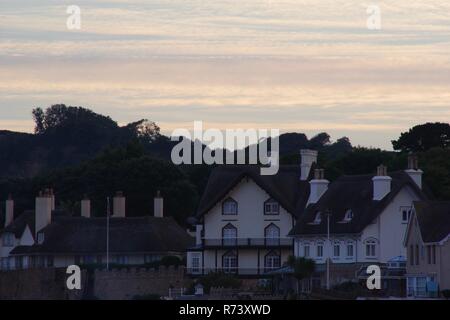 Et Rock Cottage front de chaume Lodge Chalets sur un coucher de soleil d'été. La ville de Sidmouth, l'est du Devon, Royaume-Uni. Banque D'Images