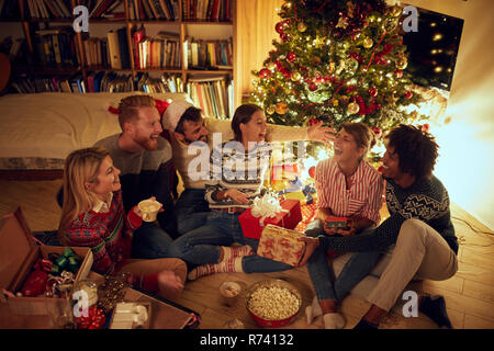 Happy friends laughing et le partage des cadeaux de Noël. Banque D'Images
