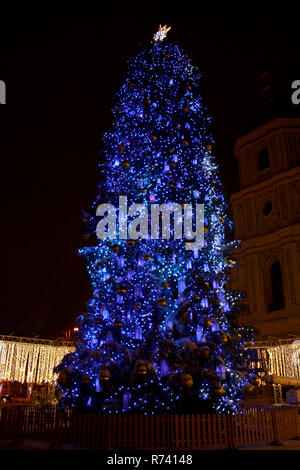 Arbre de Noël de la ville illuminée en bleu avec des guirlandes et de la cathédrale de la silhouette sur l'arrière-plan Banque D'Images