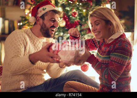 Happy young couple celebrating Christmas et avoir du plaisir ensemble Banque D'Images